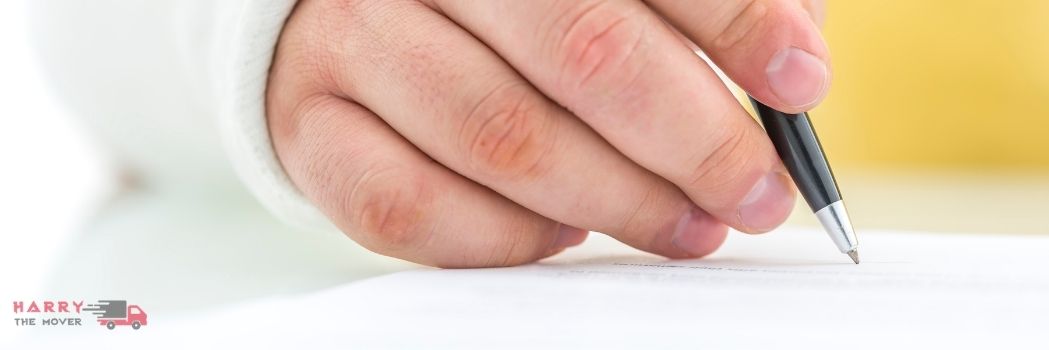 Close-up of a hand signing moving insurance documentation for Harry The Mover in Melbourne.