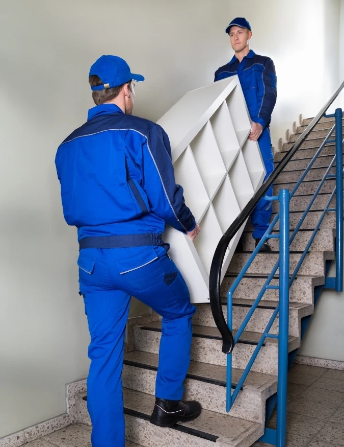 Furniture Movers Melbourne Harry The Mover furniture movers in Melbourne carefully carrying a large cabinet upstairs during move.